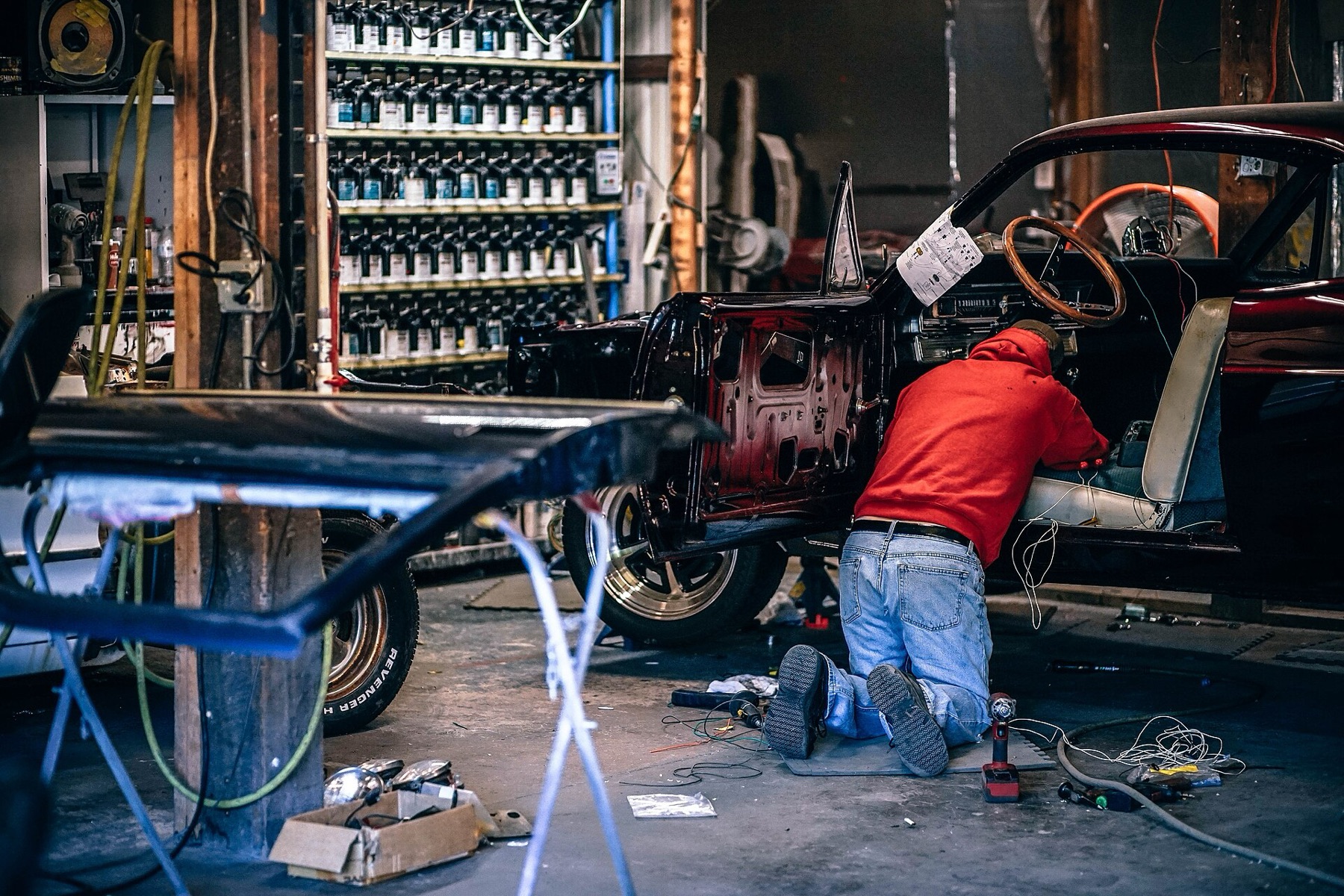 Mecánico trabajando en el interior de un coche en un taller